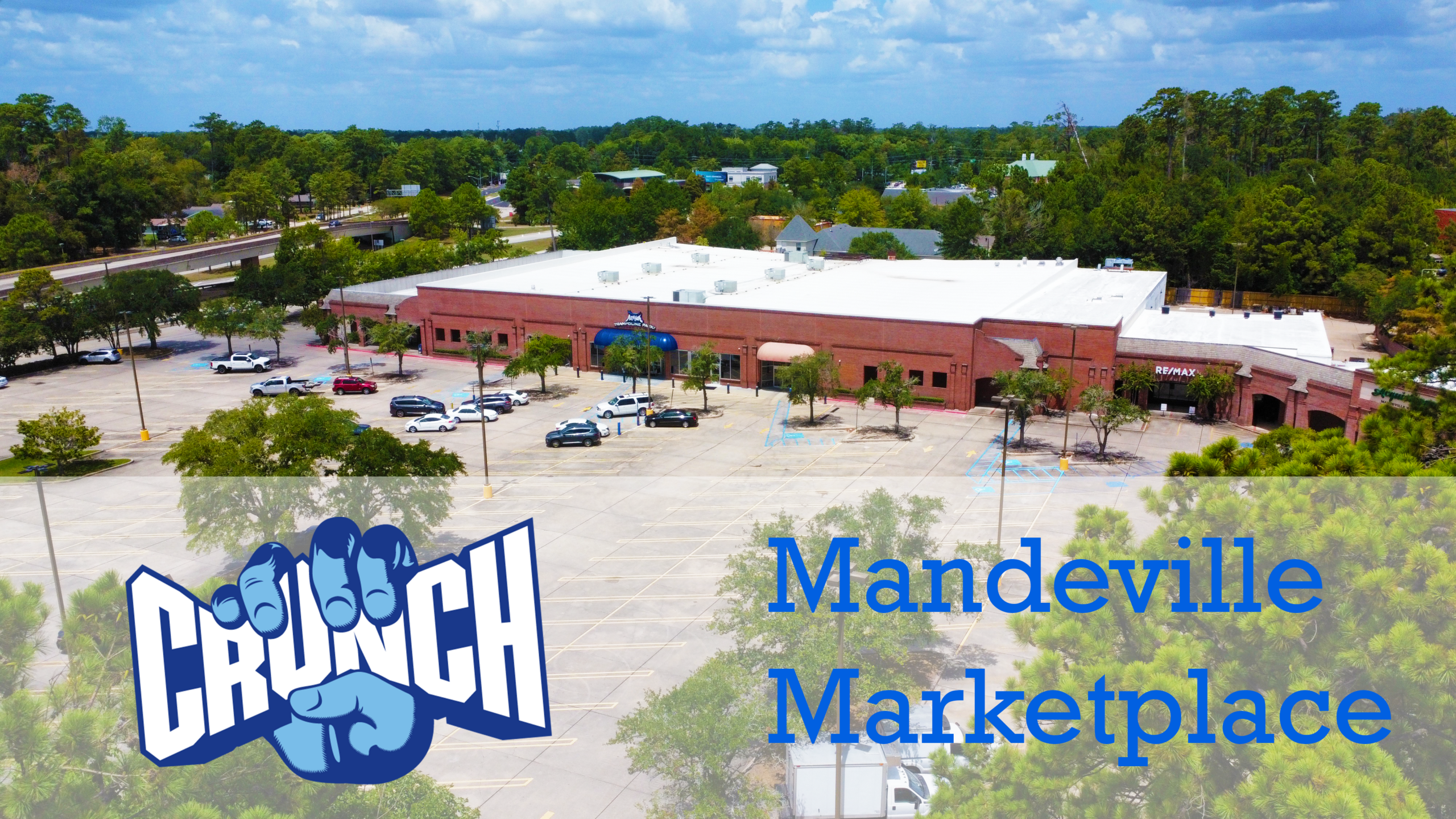 The new Crunch Fitness building at Mandeville Marketplace, with their logo overlaid at the bottom.